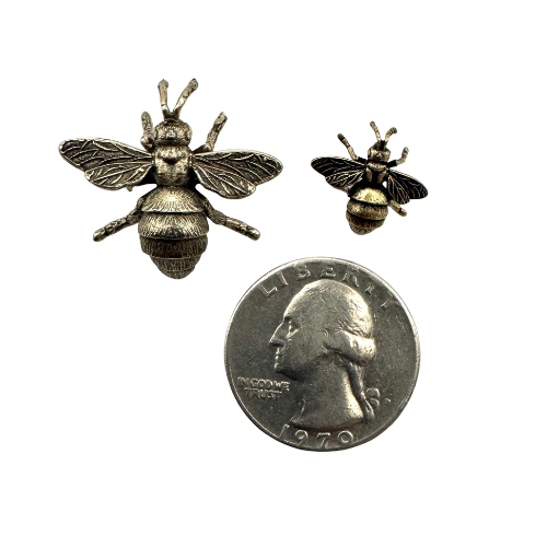 Small and medium brass bee pins shown beside a coin for scale