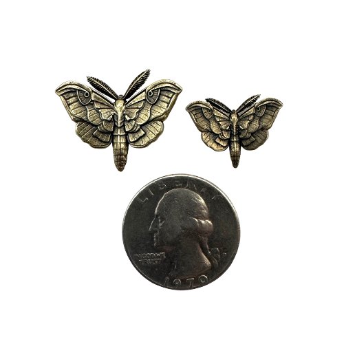 Small and medium brass moth pins shown beside a coin for scale
